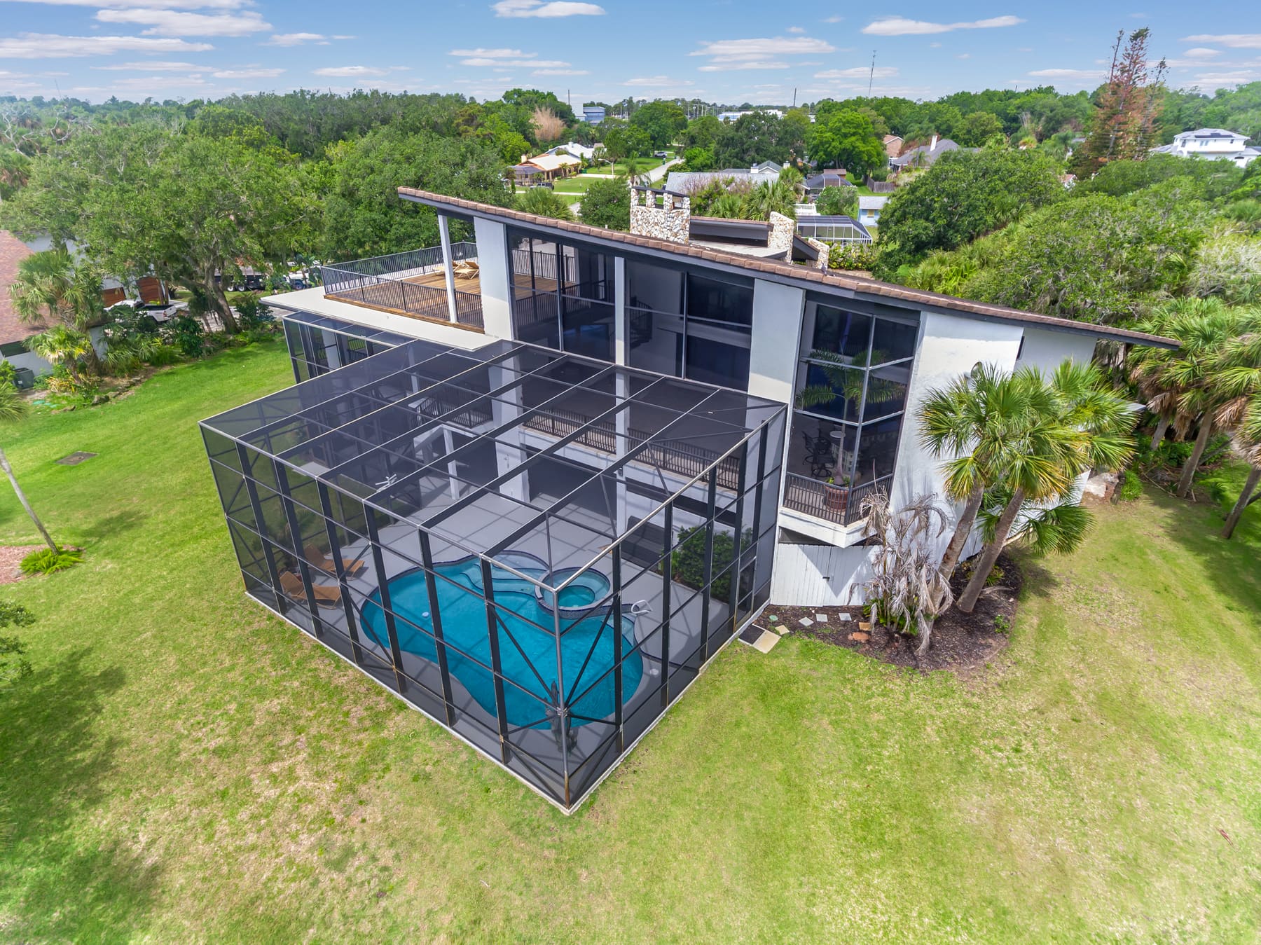 Aerial view of the pool, patio, and river beyond